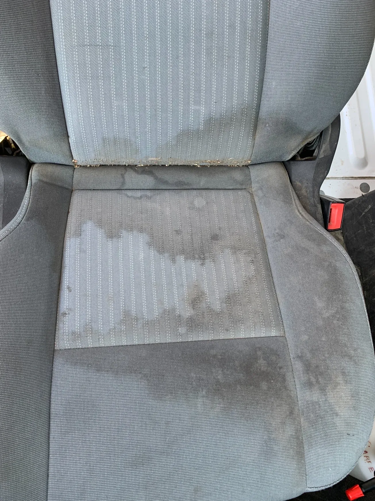 A close up of a dirty car seat in a car.