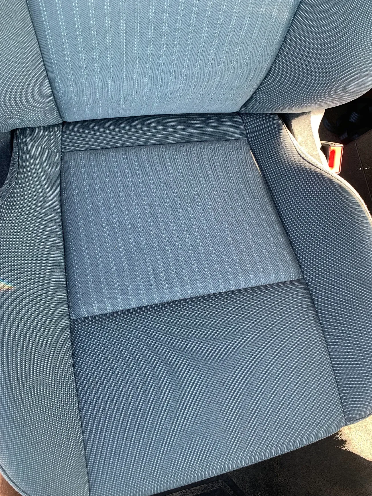 A close up of a blue seat in a car.