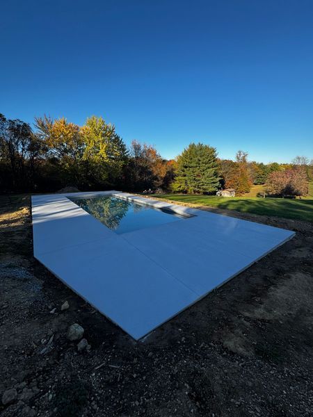 Rectangular reflective pool or skylight set in a white slab outdoors under a clear blue sky