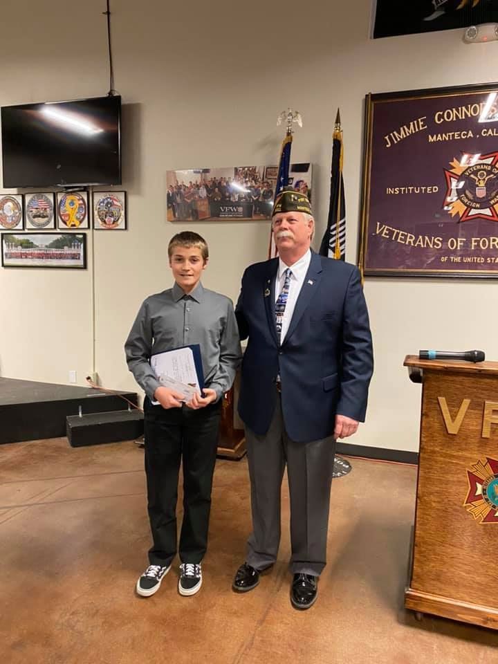 A man and a boy are standing next to each other in a room.