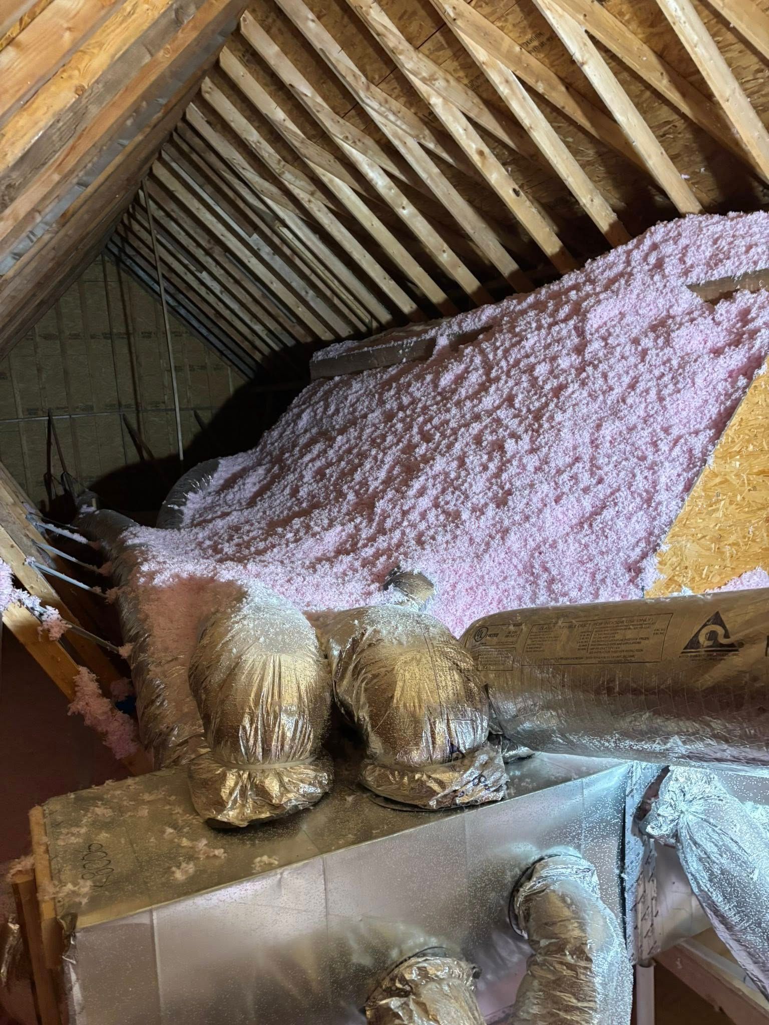 Large fox-like sculpture in an attic, covered with pink and gold textured material.