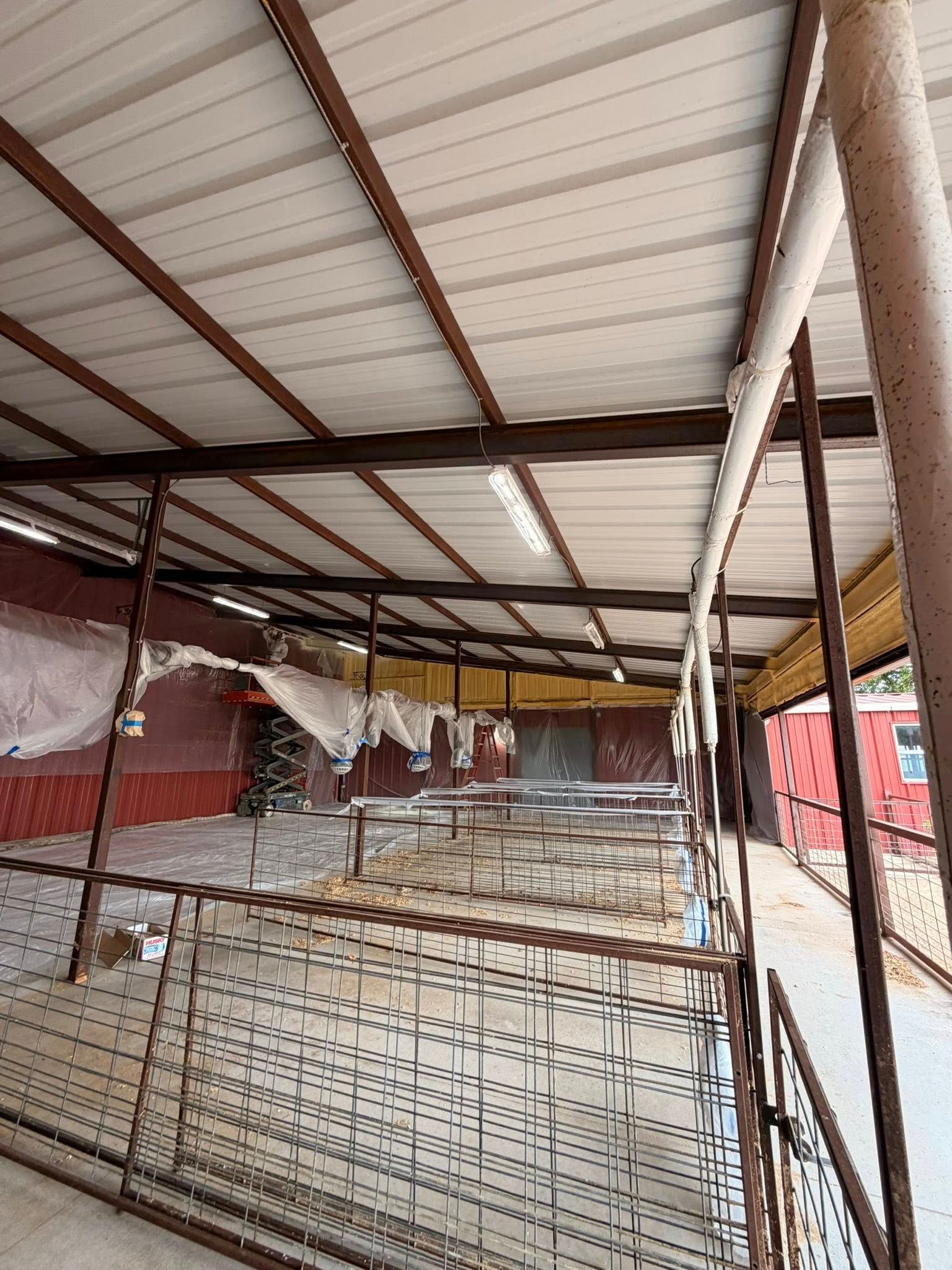 Covered market stall with metal racks, corrugated roof, and red fabric walls in an open-air setting
