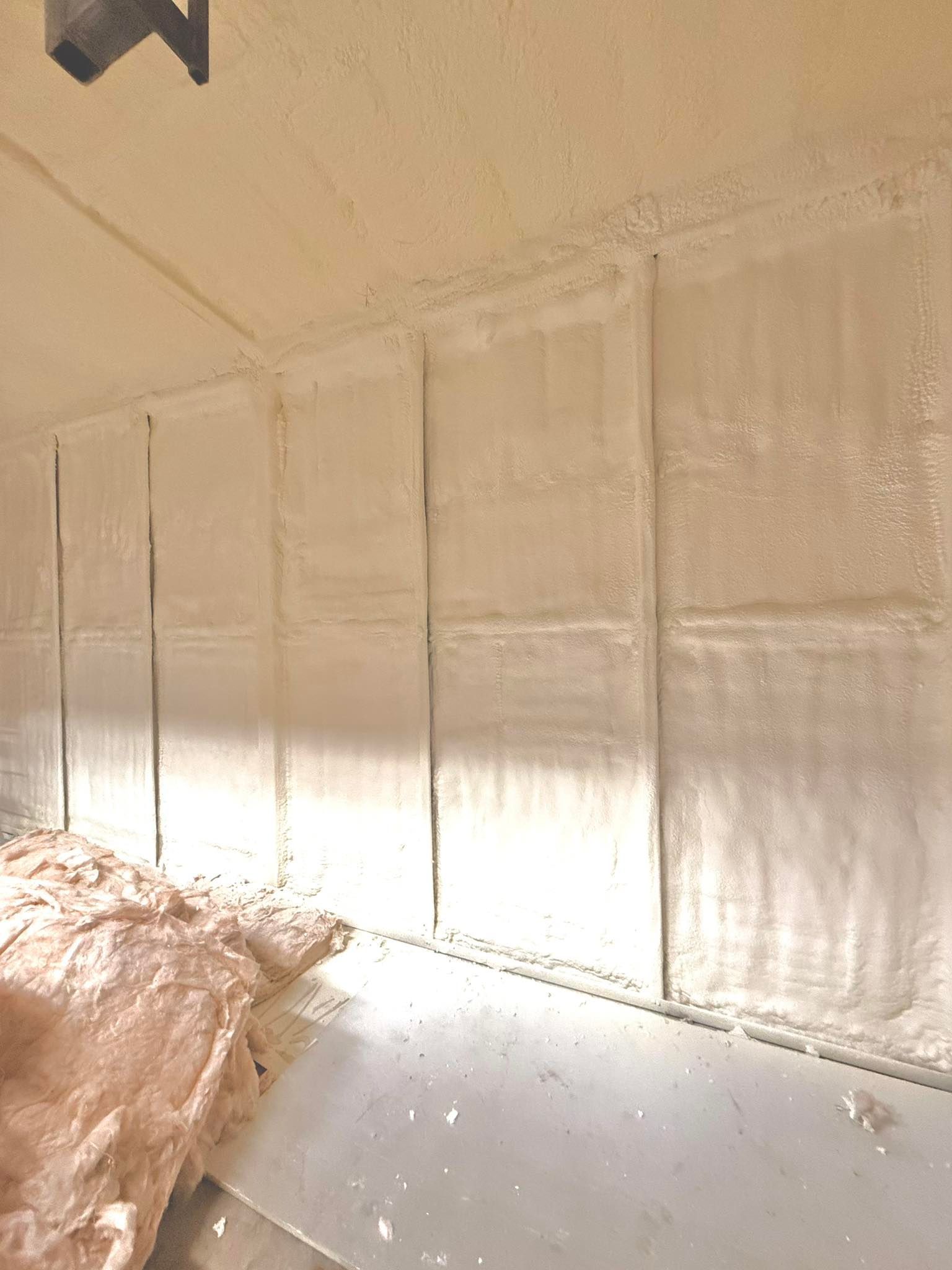 Beige painted concrete tunnel wall with water stains and bright light along the floor
