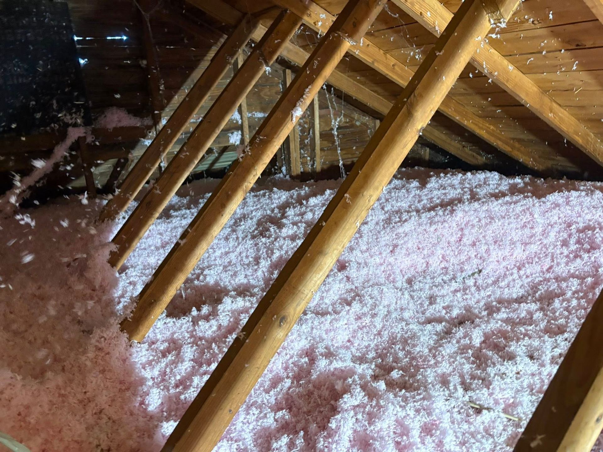 Abandoned interior with exposed insulation, debris-covered floor, and hanging plastic sheeting.