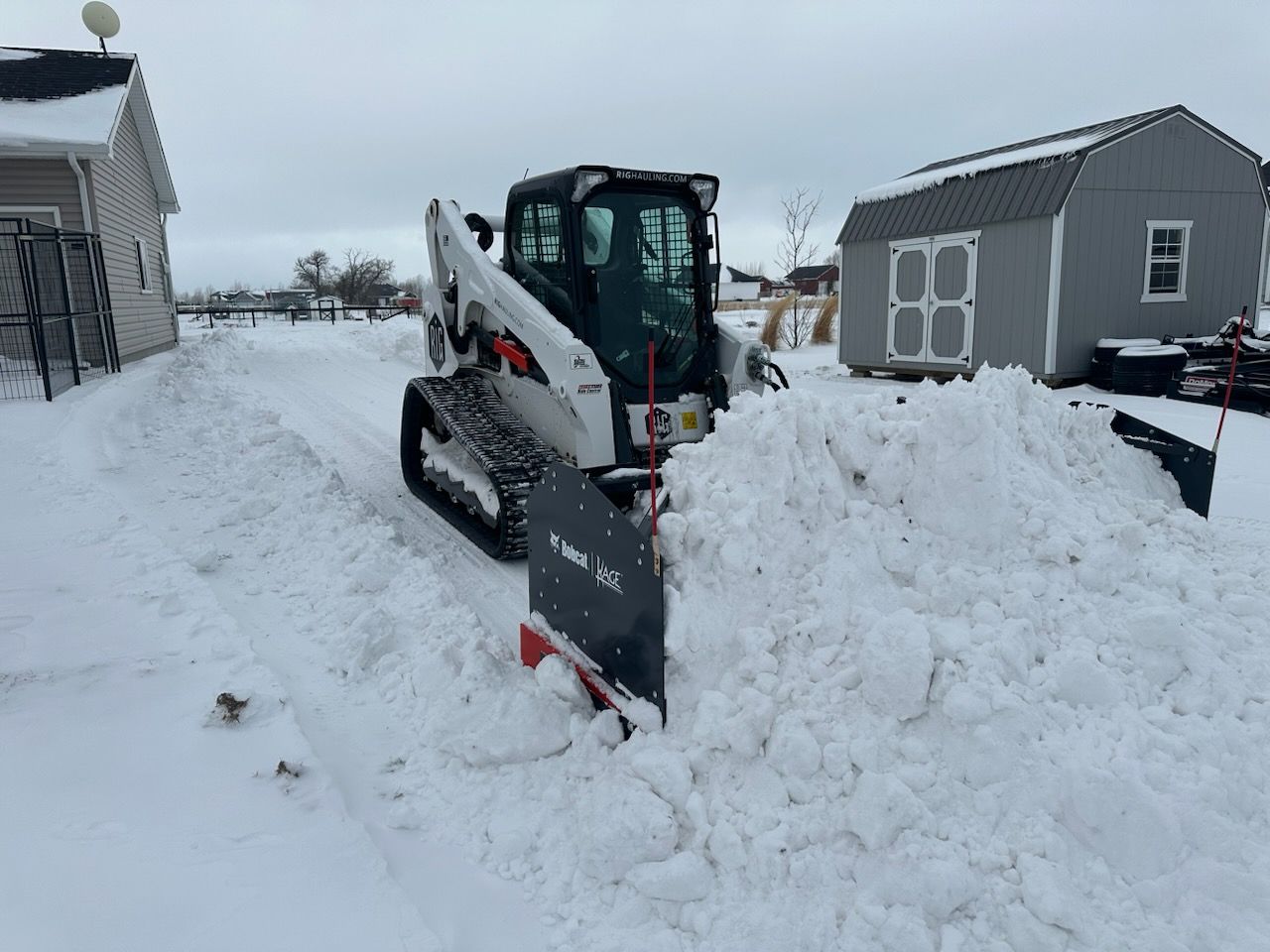 a snow plow is clearing snow from the side of a road .