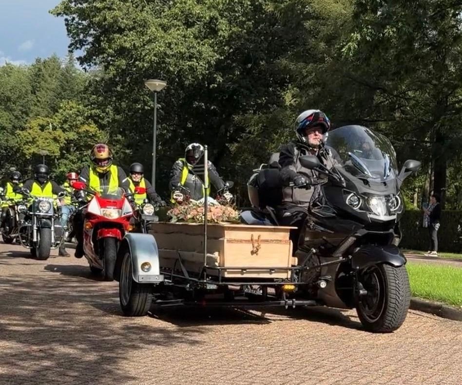 BMW rouwmotor in een rouwstoet met andere motorrijders