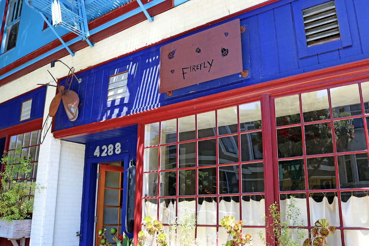 Blue storefront with red window frames, number 4288, and a hanging sign above the entrance.
