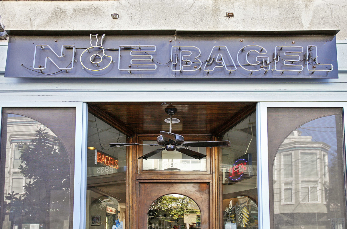 Storefront with a blue “Nice Bagel” sign above glass double doors.