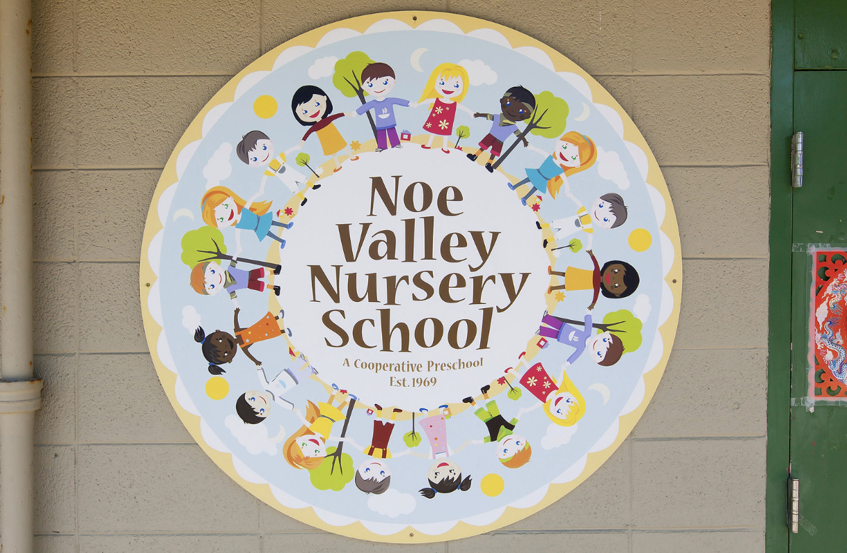 Noe Valley Nursery School sign with children holding hands in a colorful circle on a wall