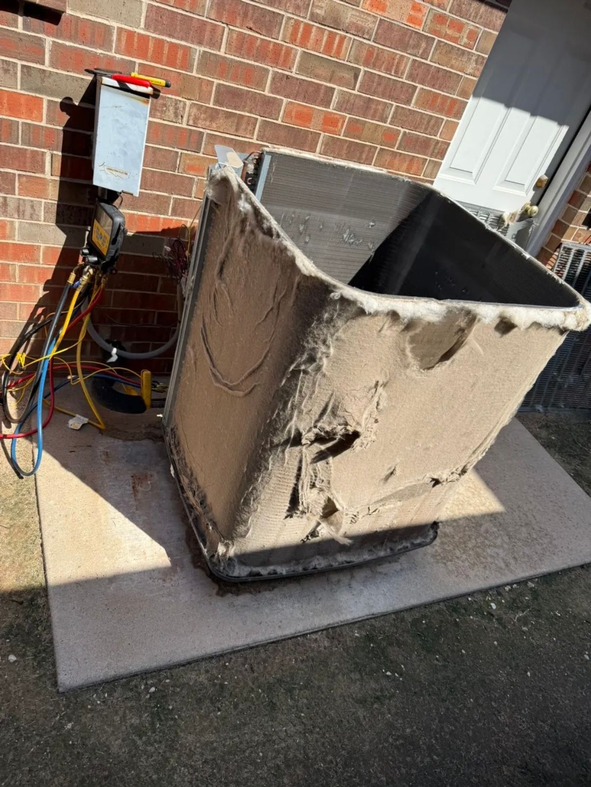 Hands of a repair person working on air conditioning unit using tools.