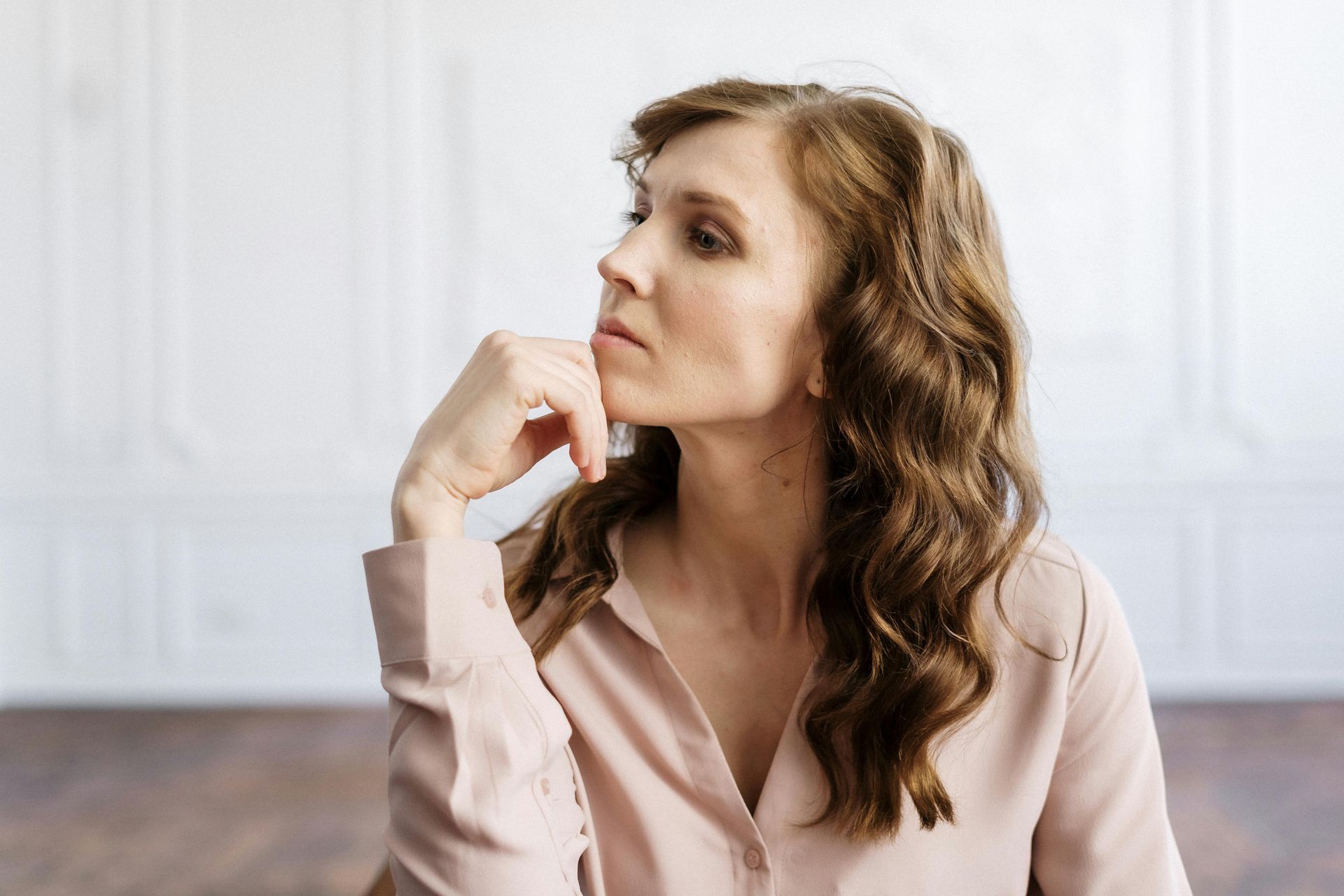 Canadian therapist sitting at a desk looking thoughtful, while contemplating practice growth.