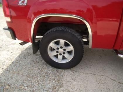 A red pickup truck with a Z71 4x4 emblem, featuring a chrome wheel arch trim over a rear tire on a gravel surface.