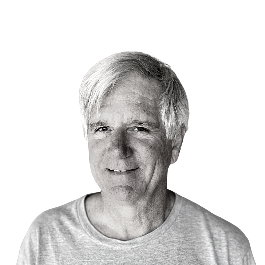 Black-and-white portrait of a smiling man in a light shirt against a white background