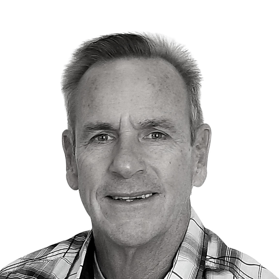 Close-up portrait of a smiling man in a plaid shirt against a white background