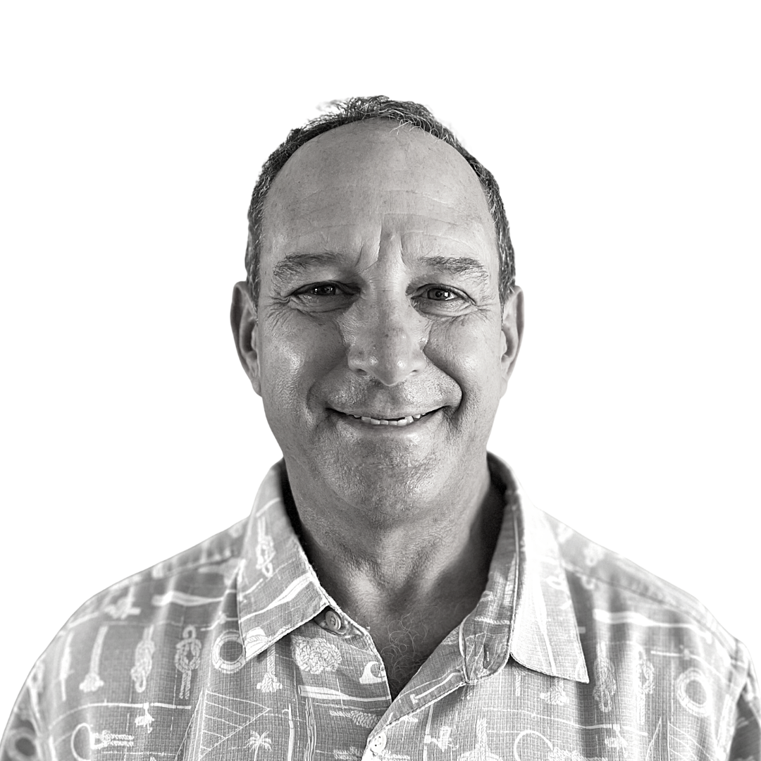 Smiling man in a patterned collared shirt against a plain white background