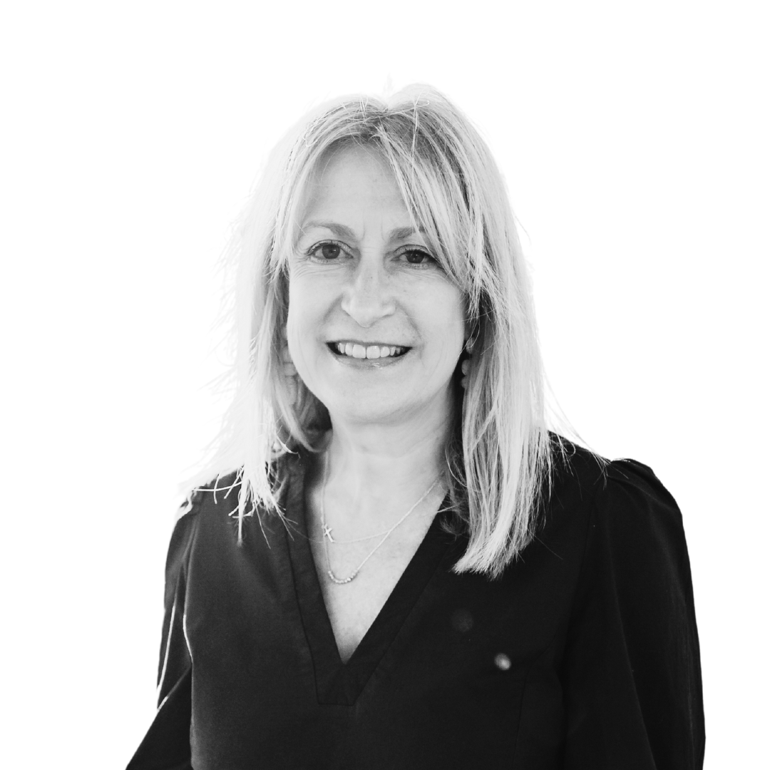 Smiling woman with shoulder-length blonde hair in a black top, posed against a white background