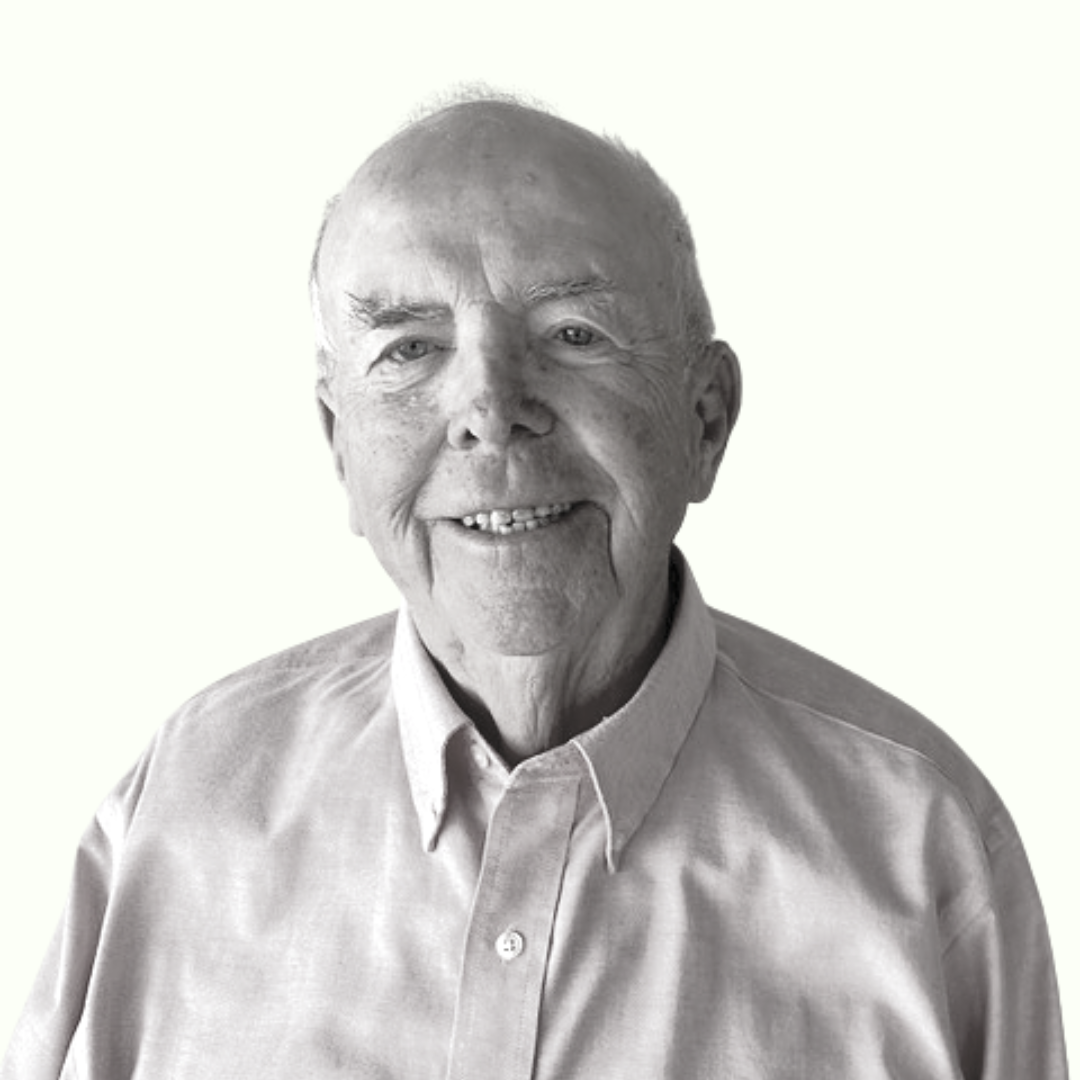 Smiling man in a light button-up shirt against a plain white background