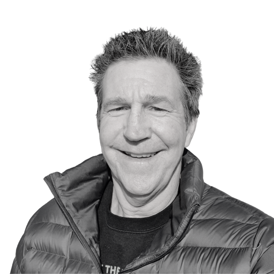Smiling man in a black puffer jacket against a plain white background