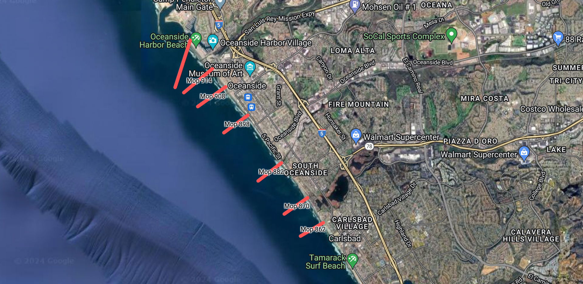 Satellite map of a coastal city with red marked spots along the shoreline