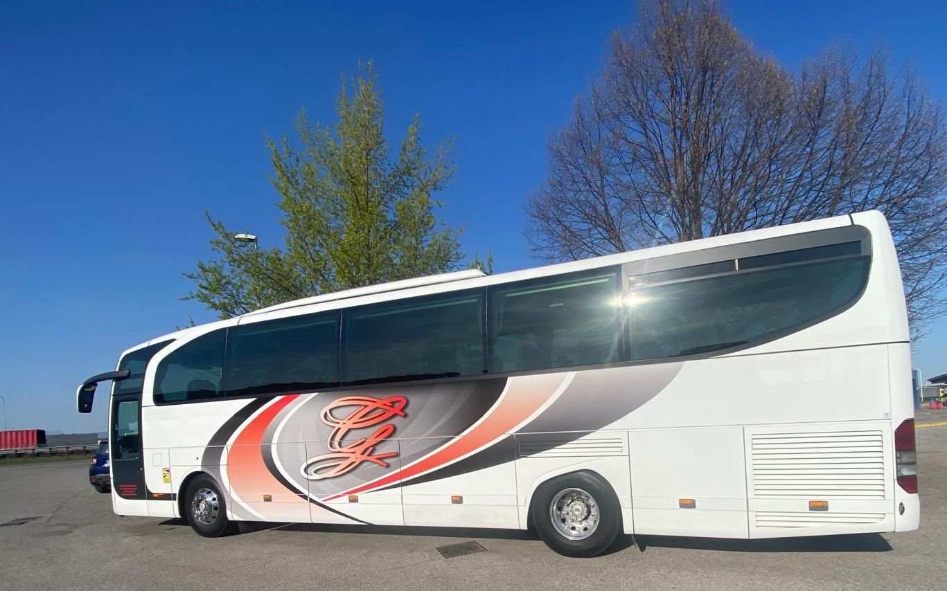 Un grande autobus bianco è parcheggiato in un parcheggio