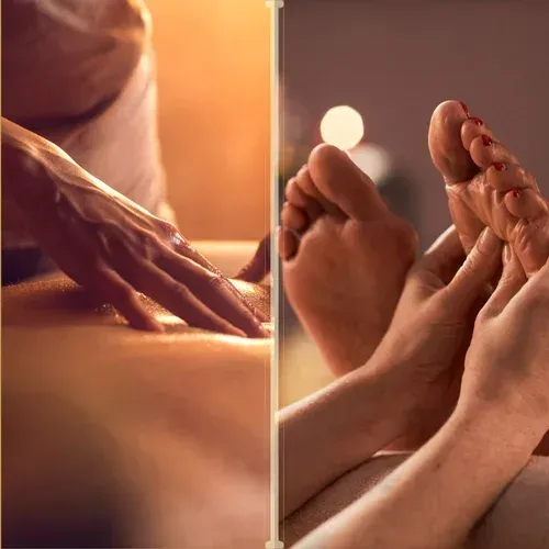 Massage therapist’s hands and feet receiving a warm foot massage in a spa setting
