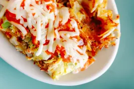 Melted cheese and red sauce on a baked dish in a white bowl