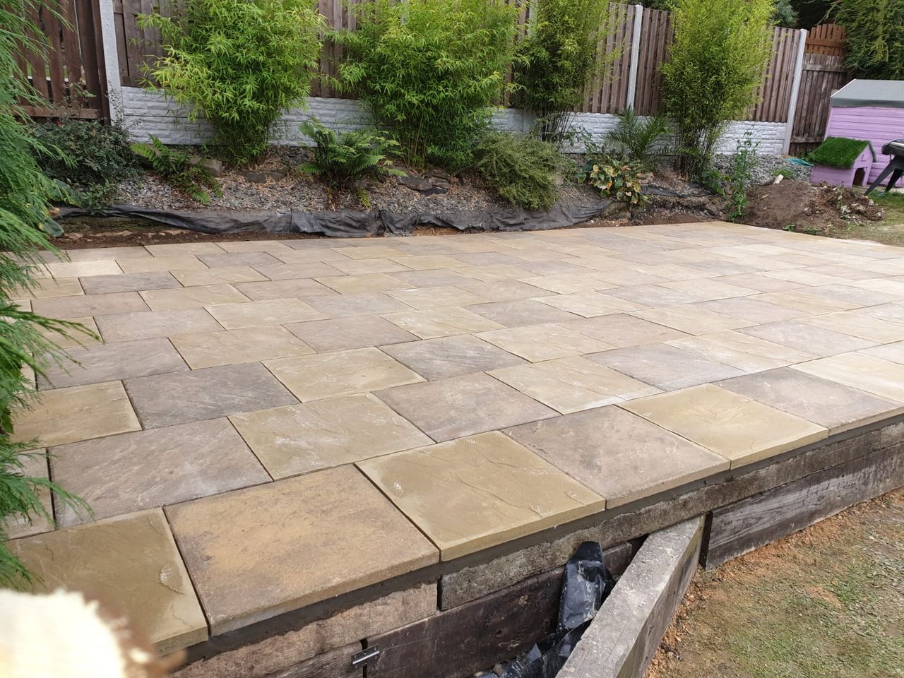 Large buff Indian stone patio in a back garden in Rotherham