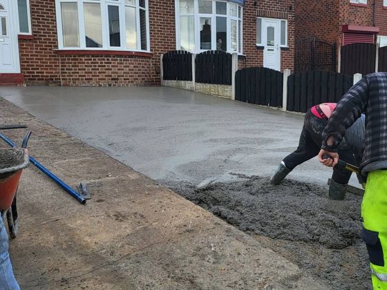 Concrete being brushed to ensure even coverage across the driveway area