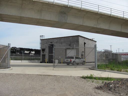 A white truck is parked under a bridge next to a building that says finder