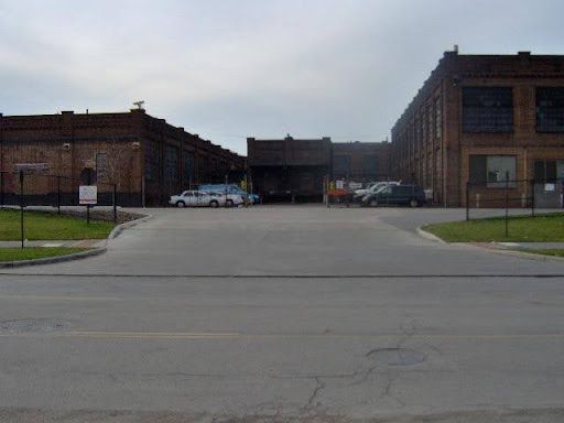 A parking lot with cars parked in front of a large building.