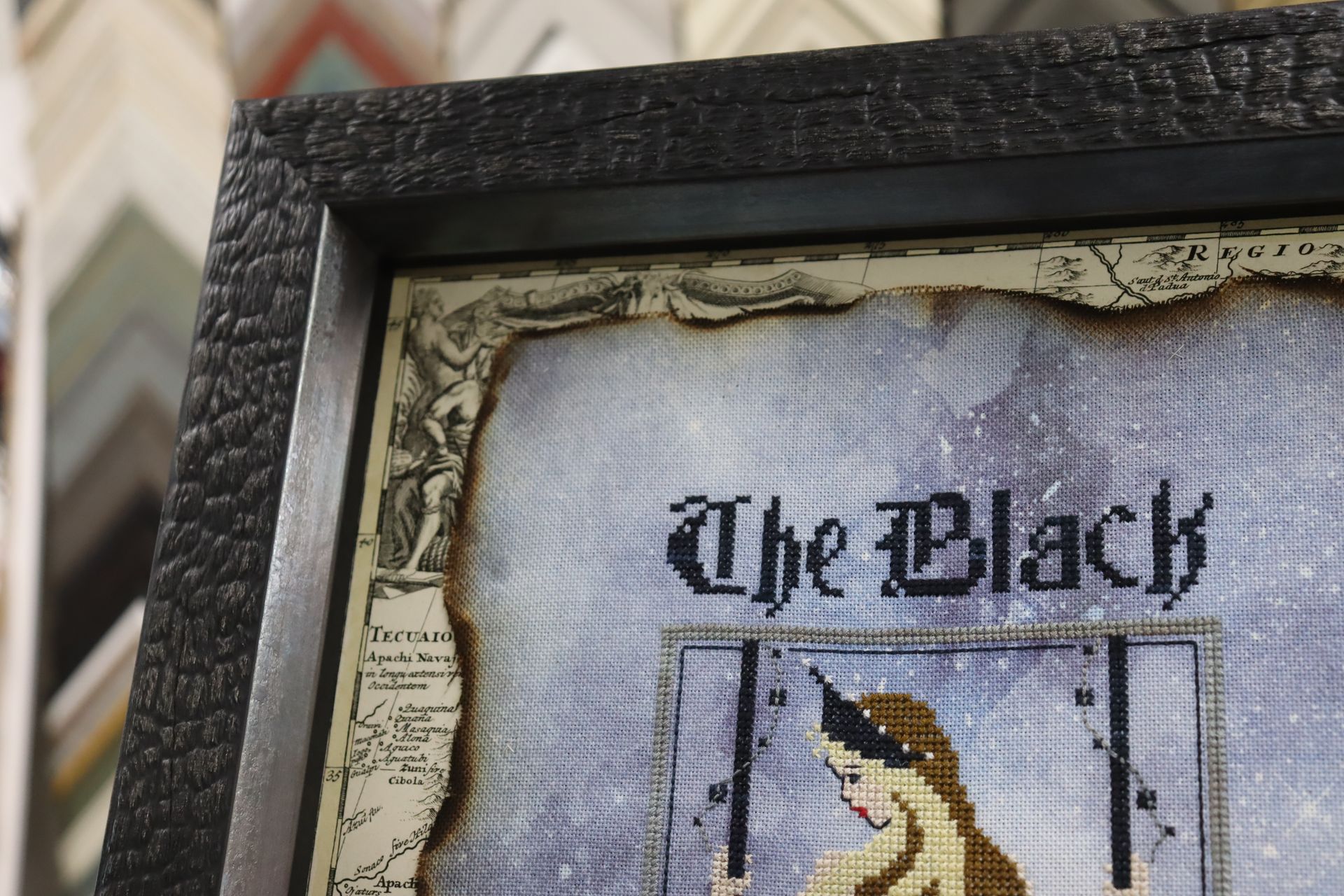 A framed cross-stitch artwork titled 