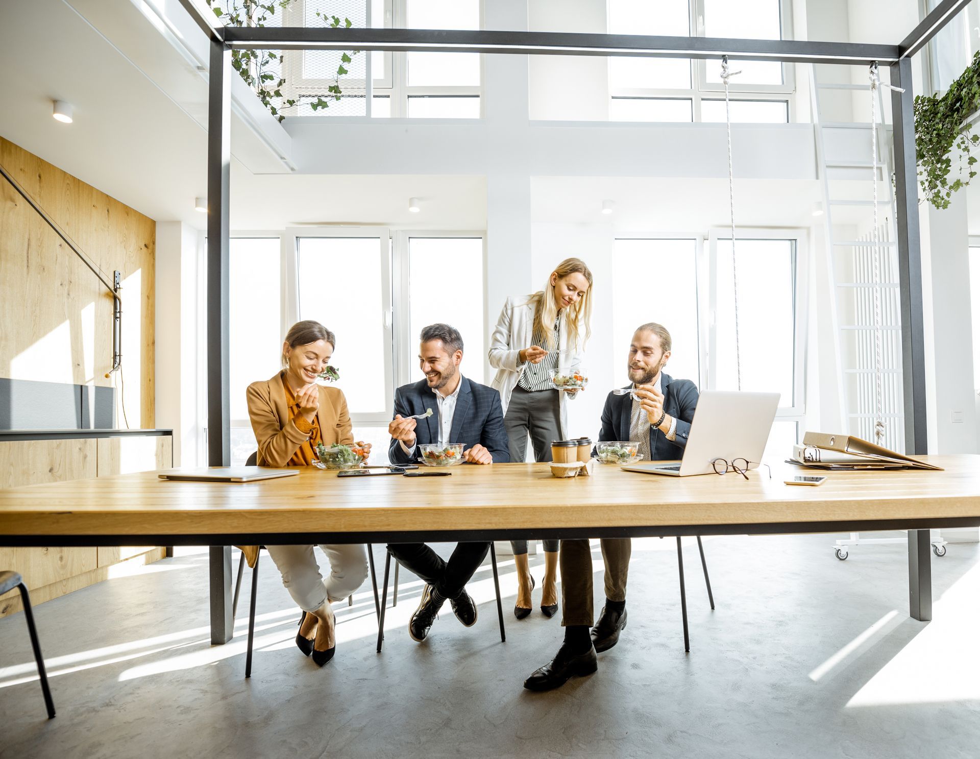 a group of people are sitting around a long table in an office