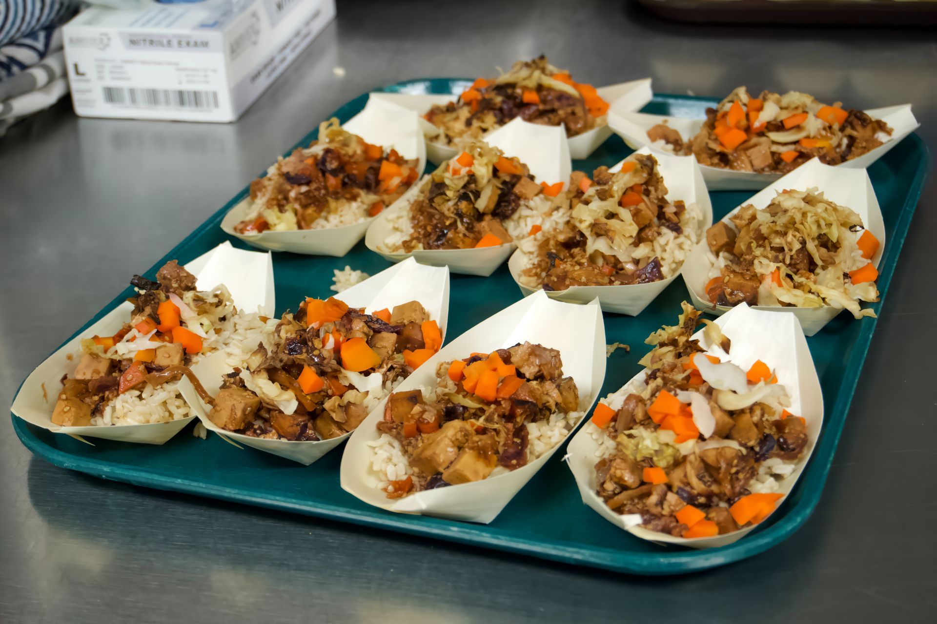 A tray of food with a box of gloves in the background