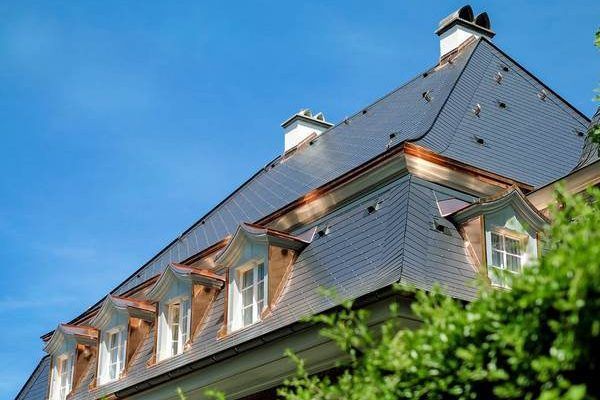 Steep dark roof with copper-trimmed dormers