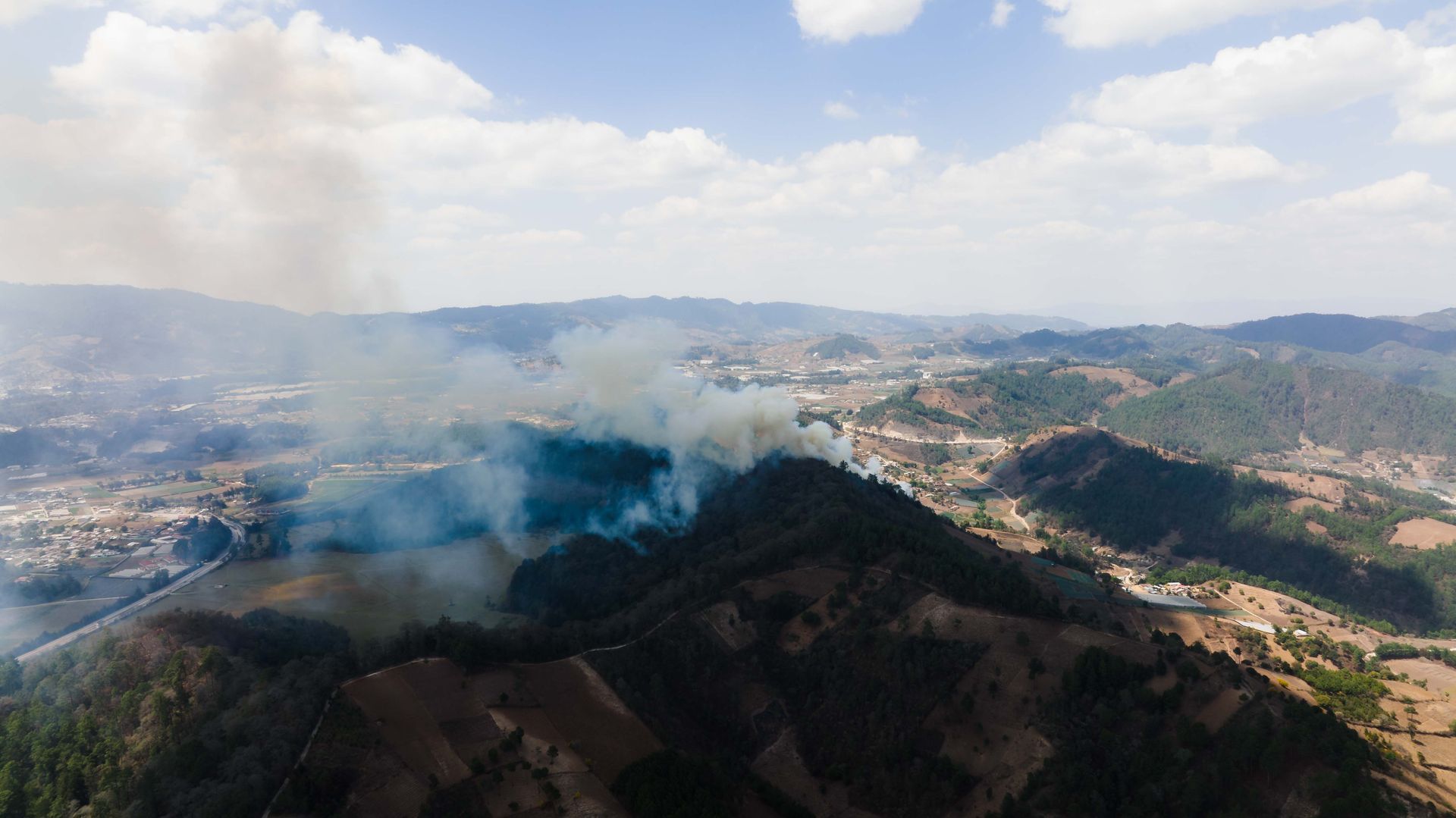 Wildfire smoke over forested foothills