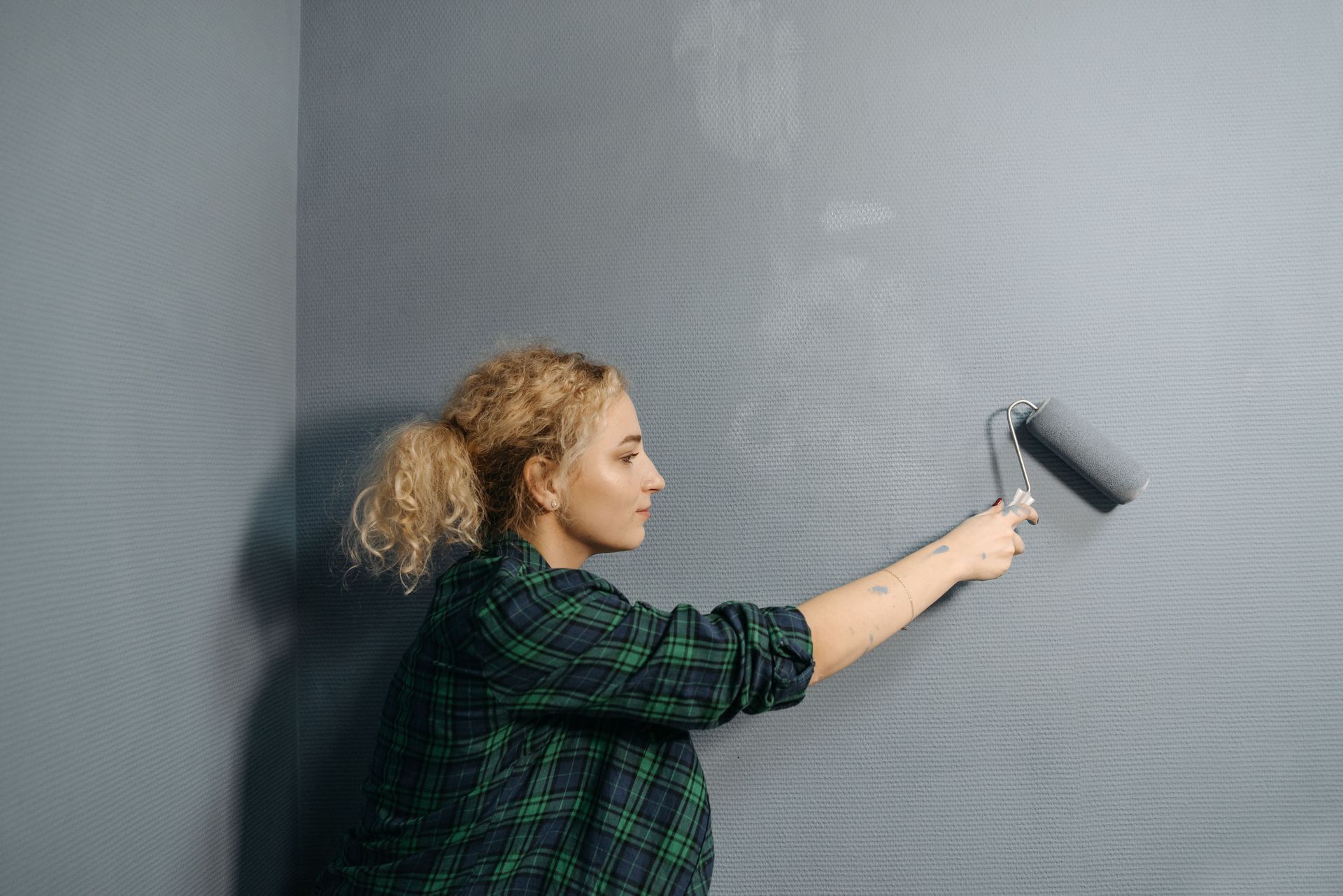 Painter rolling fresh paint on an interior wall