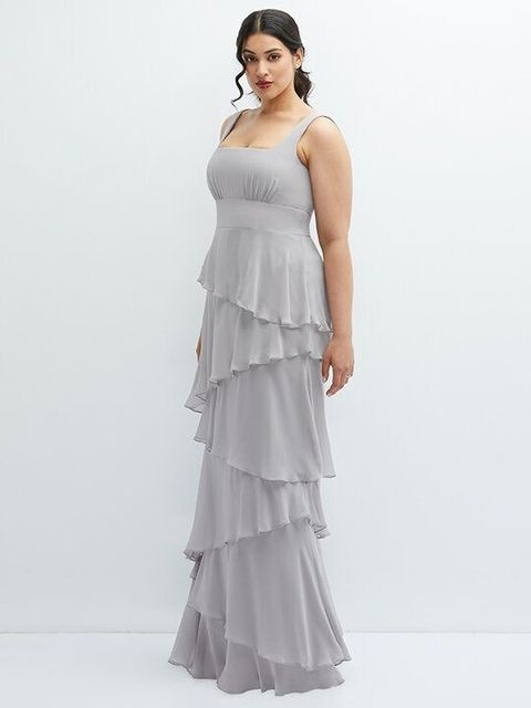 Full-length woman in a light gray tiered ruffle gown against a white studio background
