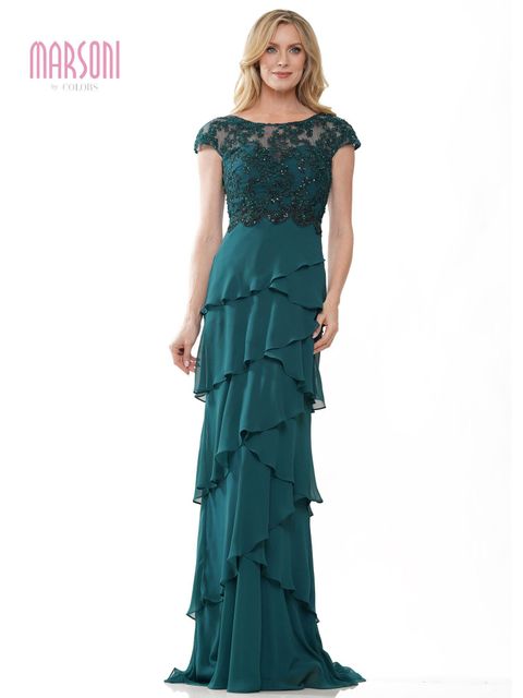 Model in a teal ruffled evening gown with a beaded dark green bodice on a white background
