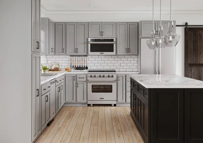 Bright modern kitchen with gray cabinets, white marble island, stainless appliances, and wood floors