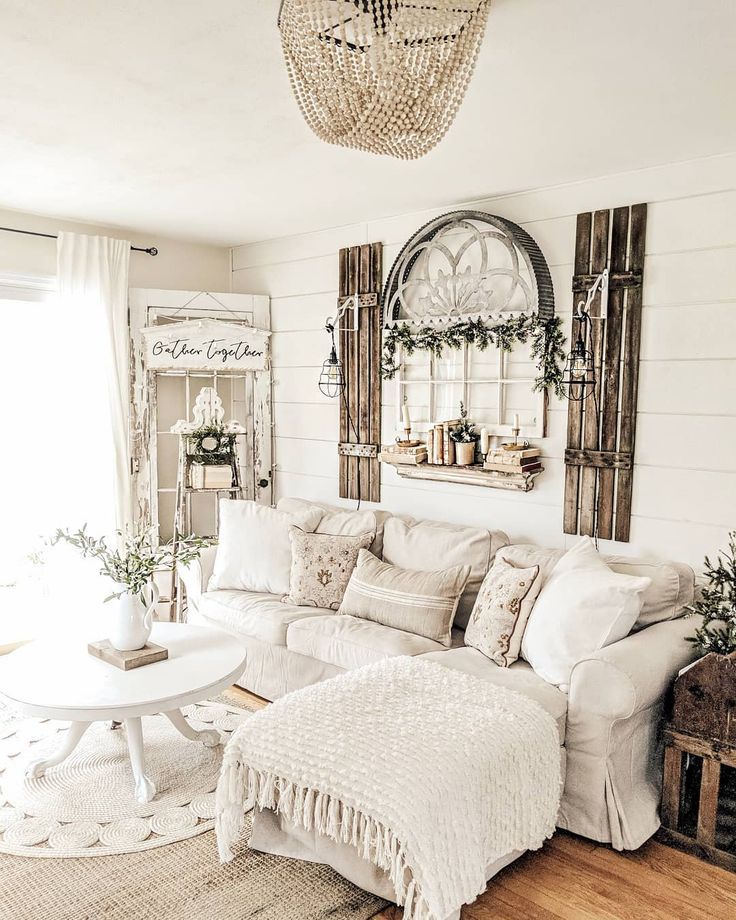 Cozy living room with white walls, cream sofa, rustic decor, and natural light.