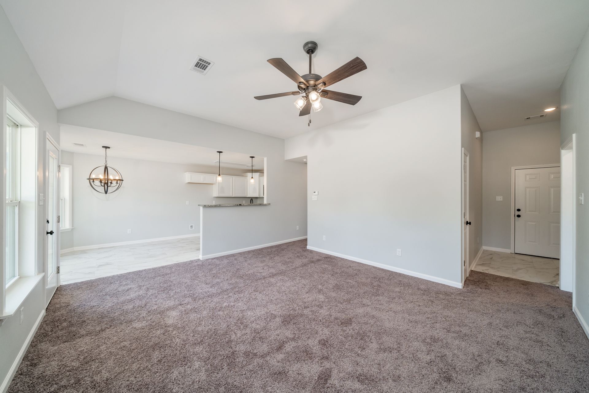 Living room with brown carpet, gray walls, and a ceiling fan.