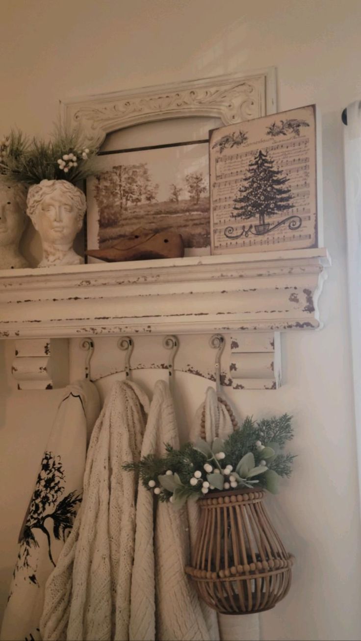 White distressed shelf with decor and hanging textiles; wicker basket with greenery.
