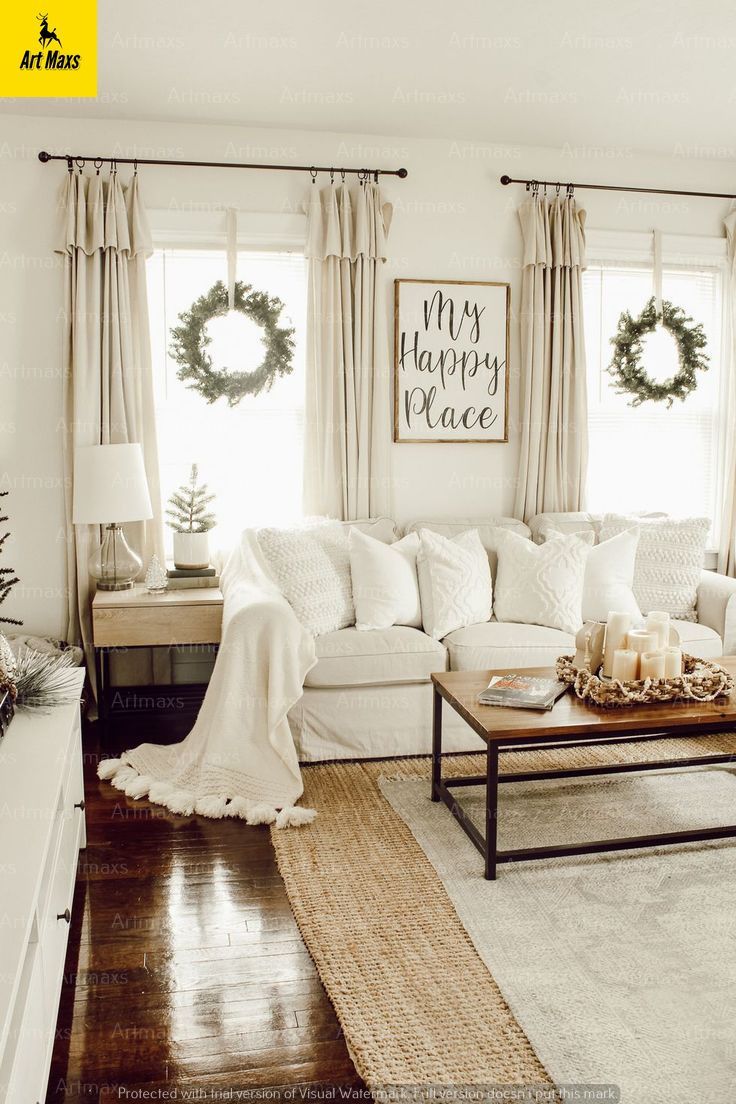 Cozy living room with neutral decor, a white sofa, wreath-adorned windows, and wooden coffee table.