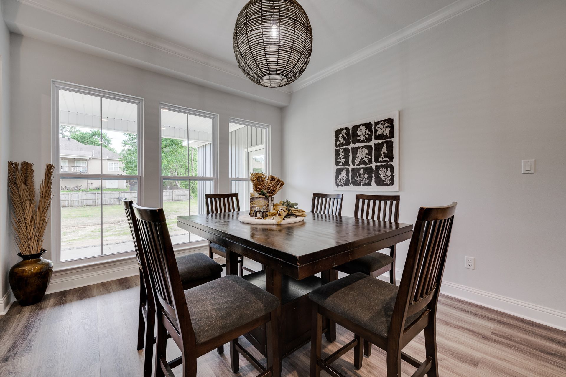 Dining room with a dark wood table, six chairs, and a decorative chandelier.