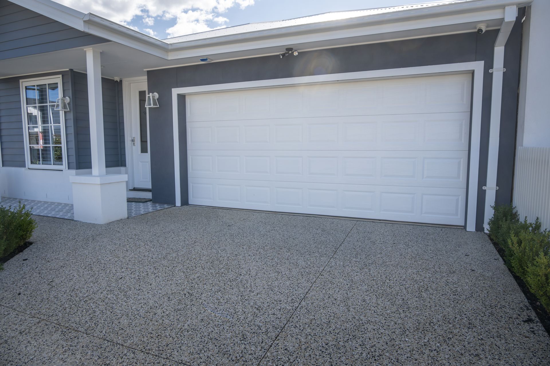 A neat double garage with a white panel lift door. A neat double garage with a white panel lift door.