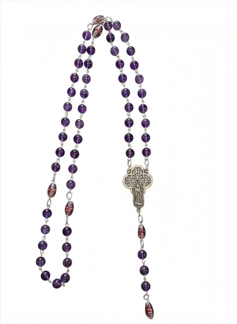 Silver crucifix necklace with pale jade beads on a wooden surface