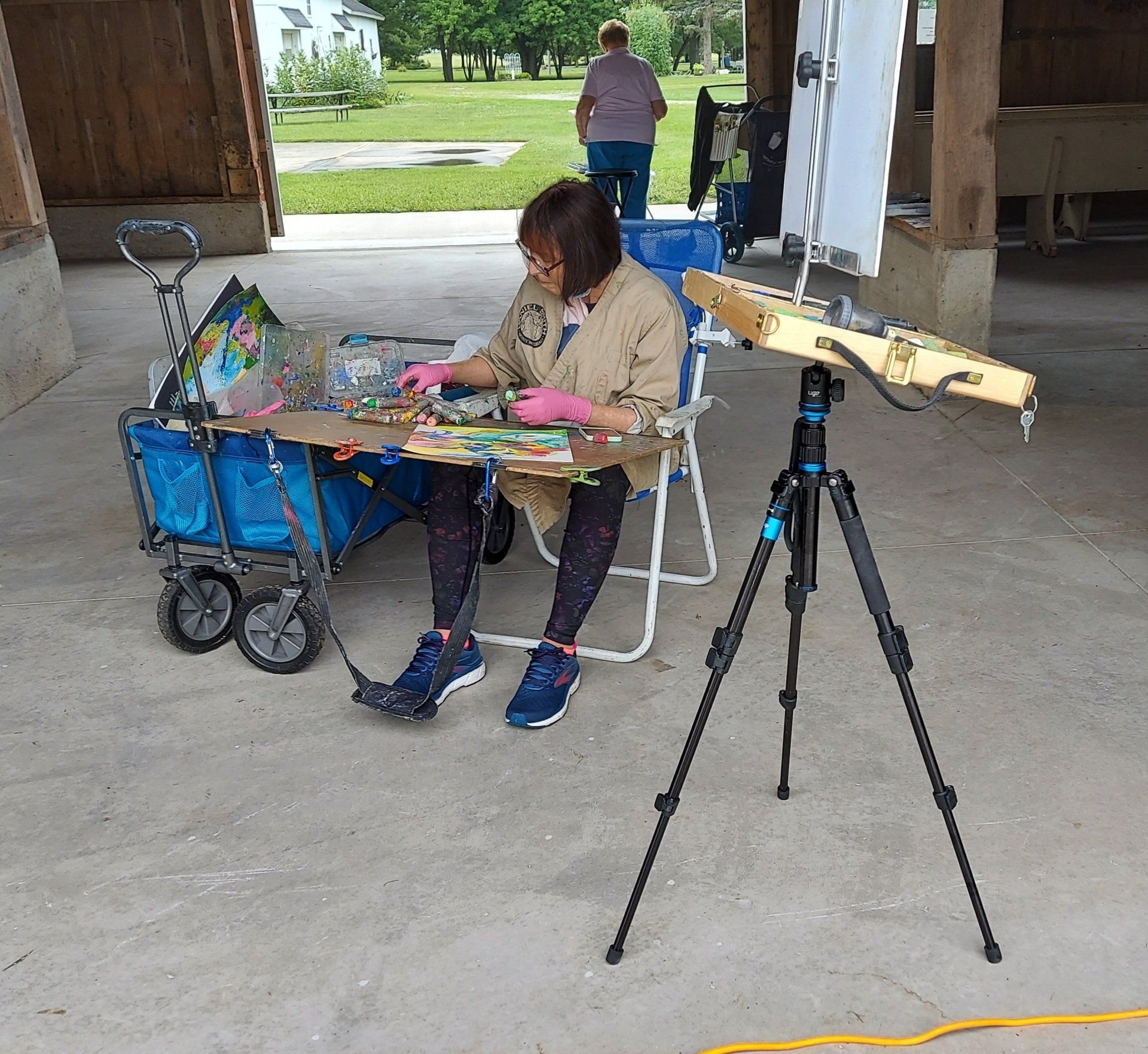 A woman is sitting at a table with a wagon in the background