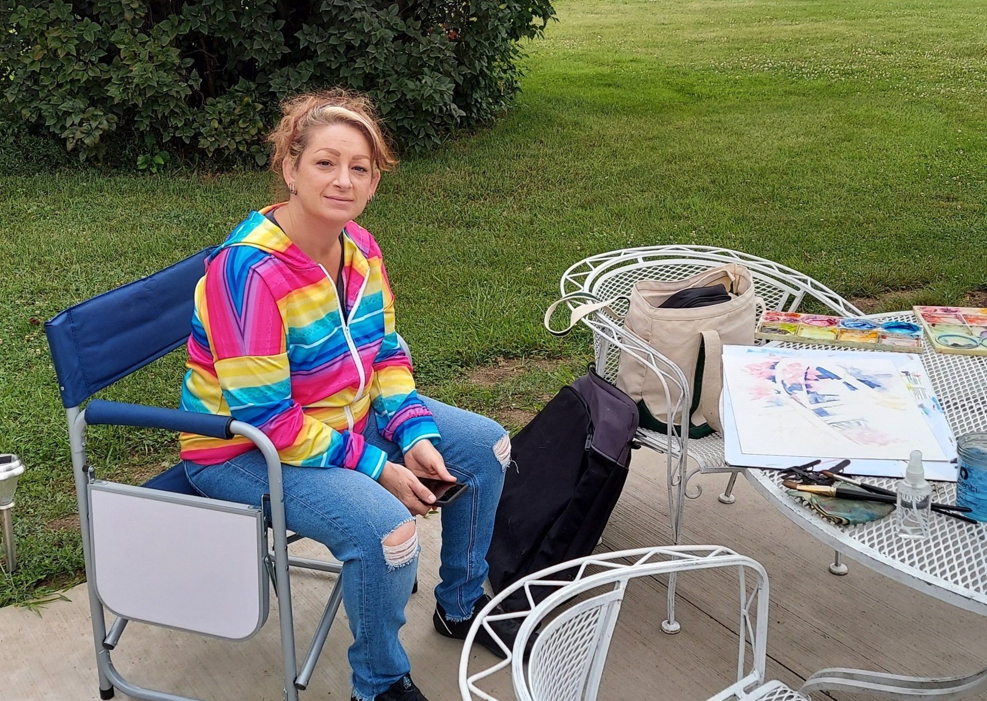 A woman is sitting in a chair in front of a table.