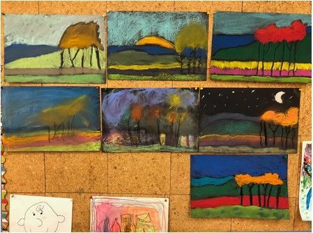 A cork board with a bunch of paintings on it