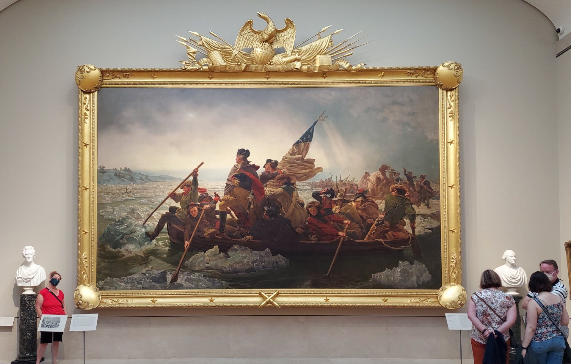A group of people are looking at a large painting in a museum